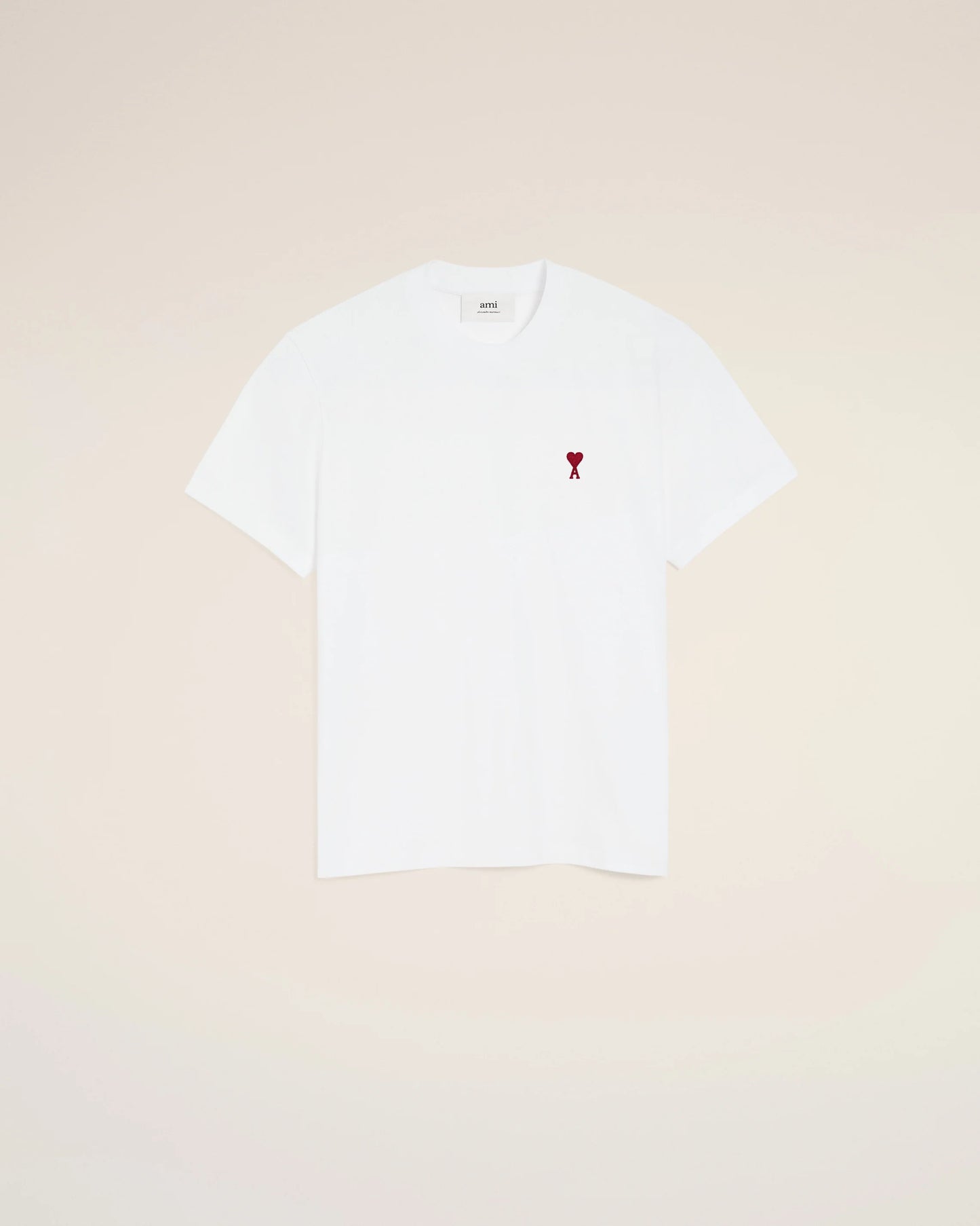White t-shirt with a small red logo on a beige background
