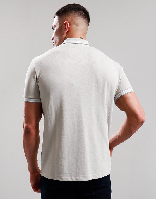 Man wearing a white polo shirt against a plain background