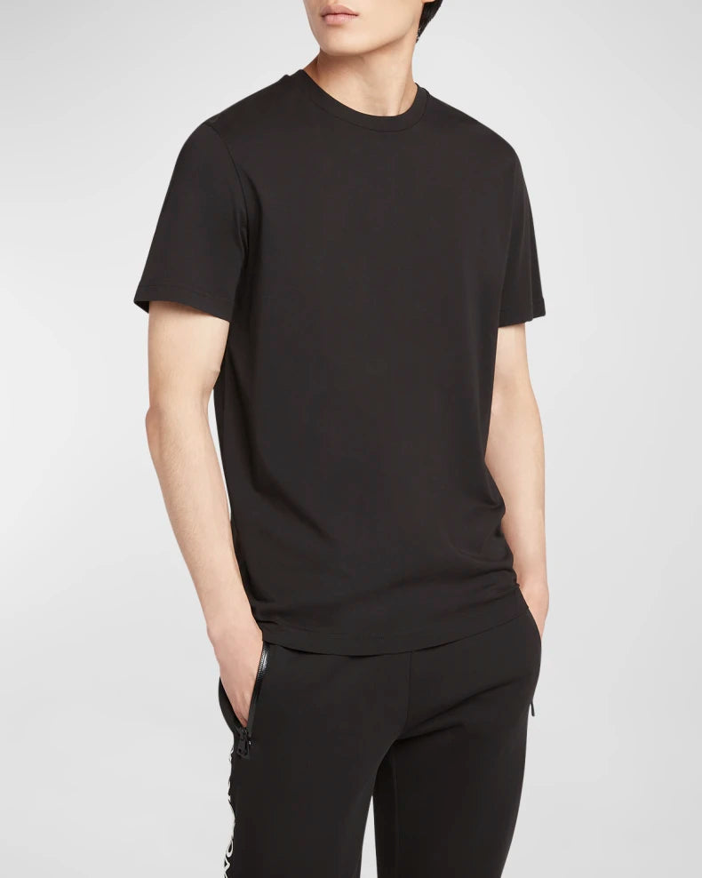 Person wearing a plain black t-shirt and pants on a white background