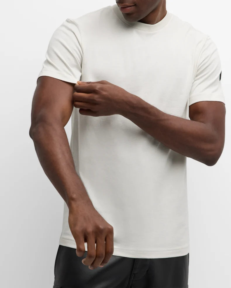 Person wearing a white t-shirt on a plain background