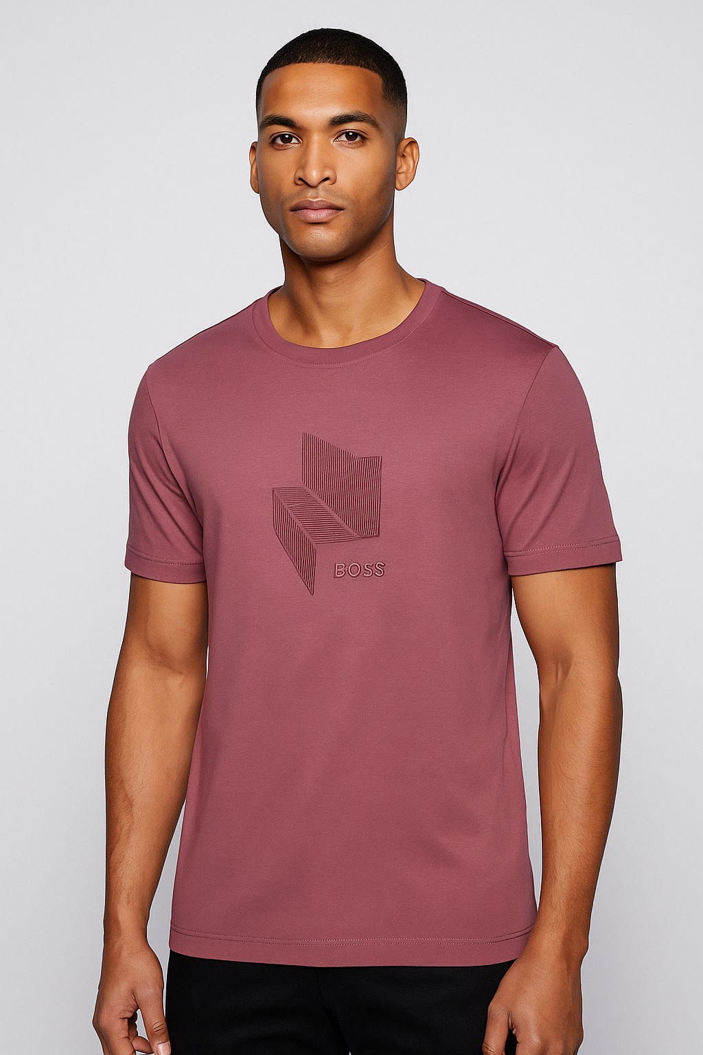 Man wearing a maroon t-shirt with a logo on a light gray background