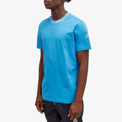 Person wearing a blue t-shirt with a brand logo on a white background