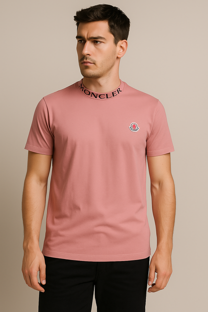 Man wearing a pink Moncler t-shirt against a beige background