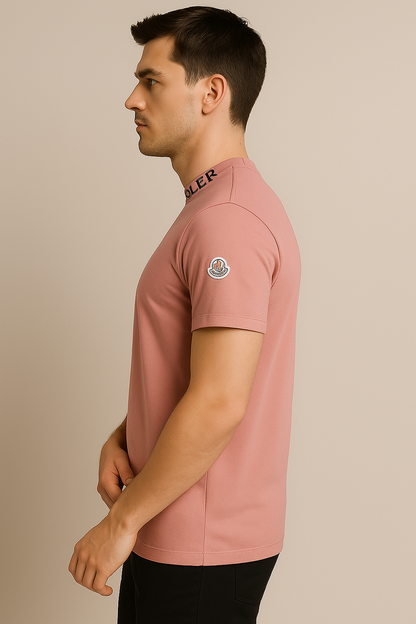 Man wearing a pink polo shirt with brand logos on a beige background