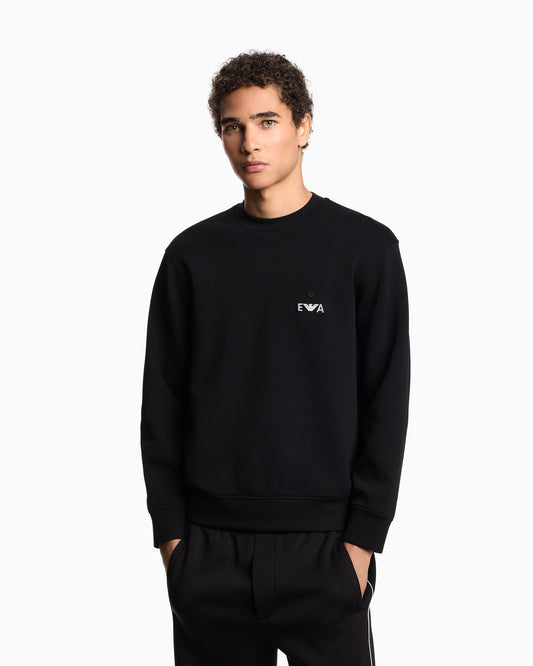 Person wearing a black sweatshirt with a logo on a white background
