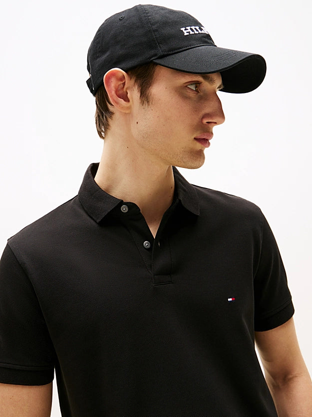Man wearing a black cap and black polo shirt on a white background