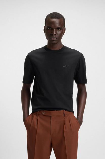 Man wearing a black t-shirt and brown pants on a white background