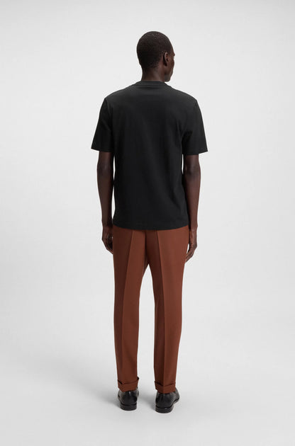 Person wearing a black t-shirt and brown pants on a white background