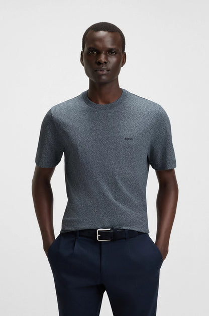 Man wearing a gray t-shirt and navy pants on a white background