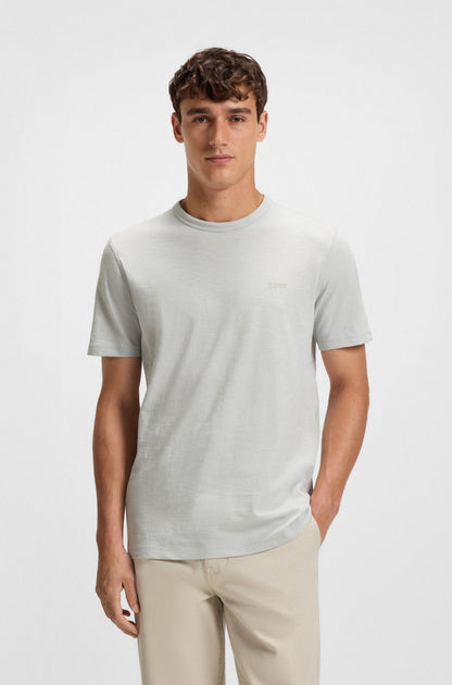 Man wearing a light gray t-shirt and beige pants on a white background