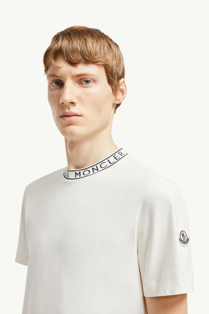 Man wearing a white t-shirt with Moncler logo on a white background