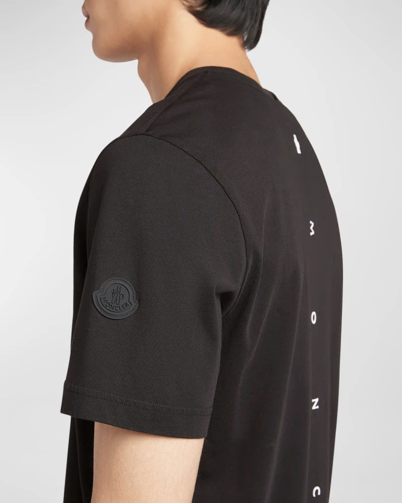 Black t-shirt with brand logo and text on a white background
